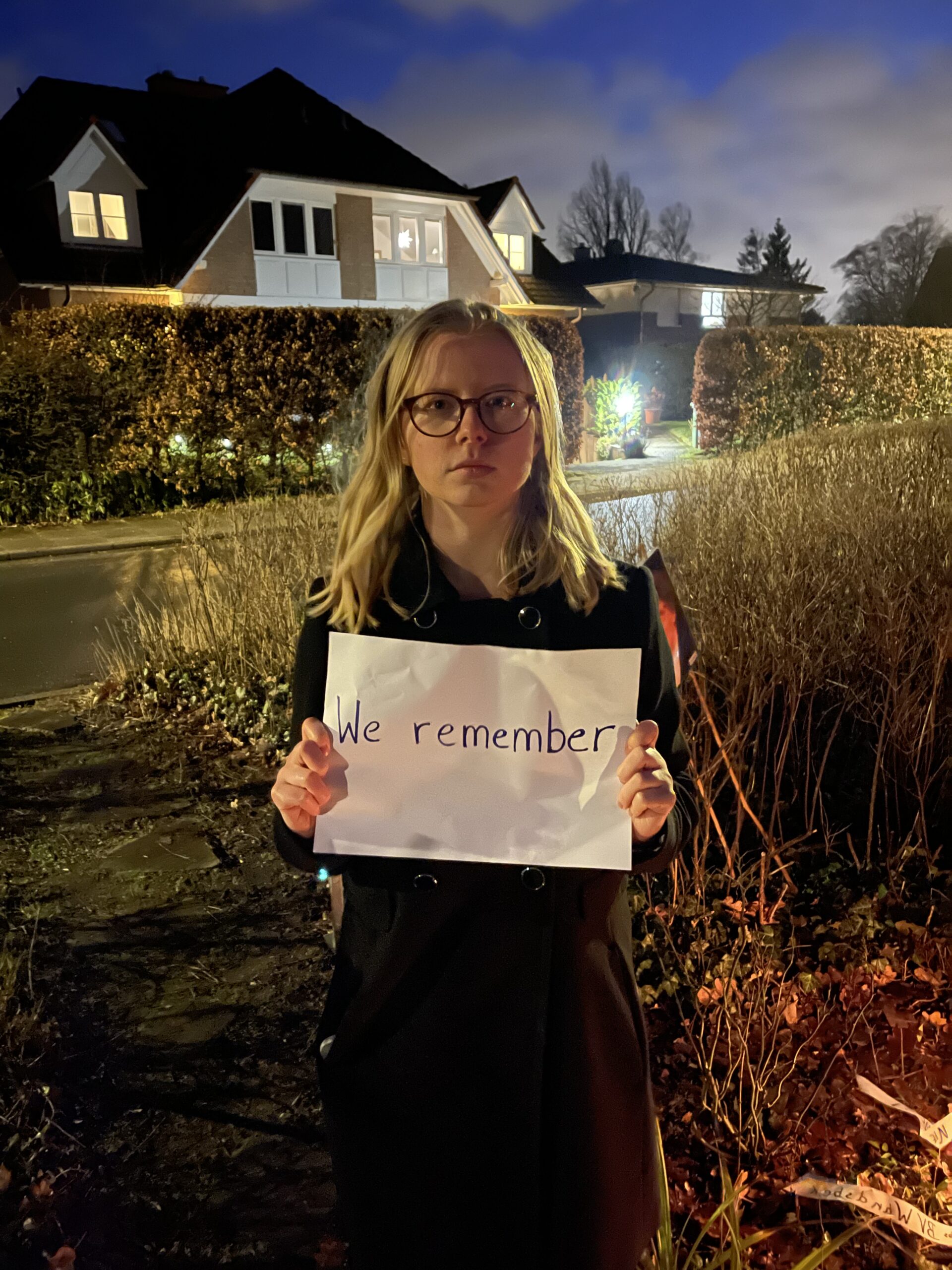 Frau und Zettel mit Aufschrift -we remember-